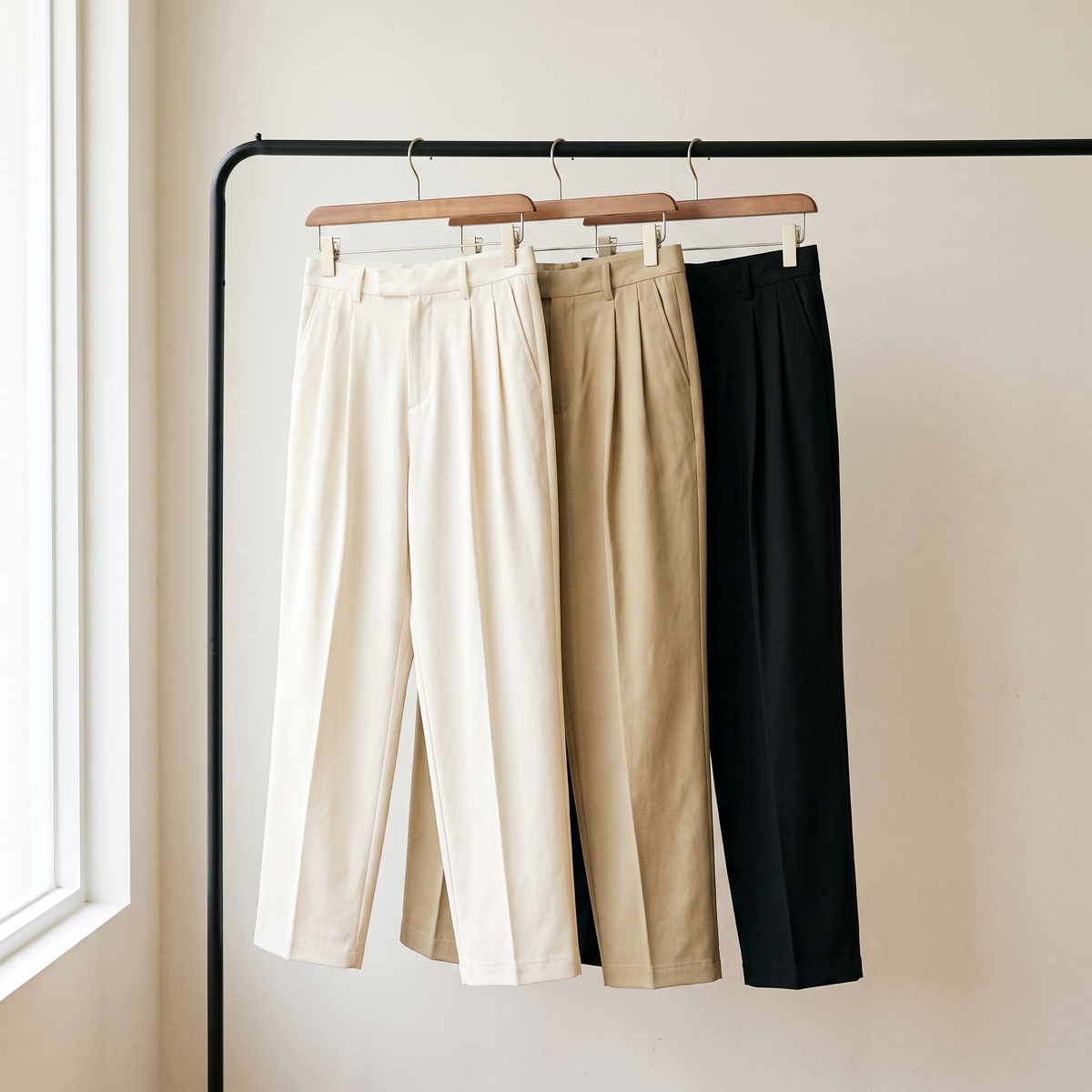 Aren trousers in white, khaki and black on a rail