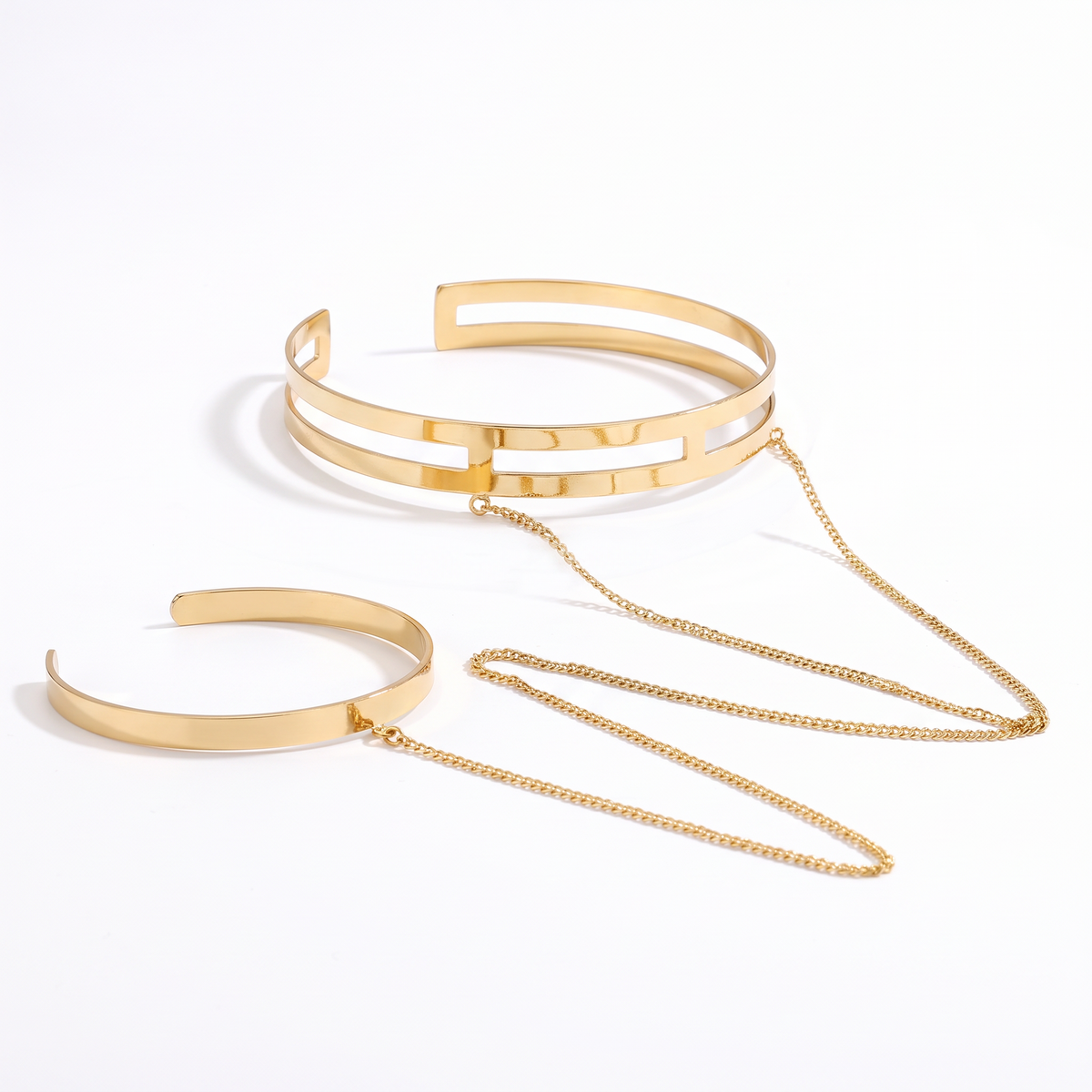 Delphine arm cuff and wrist cuff joined by a gold chain on white