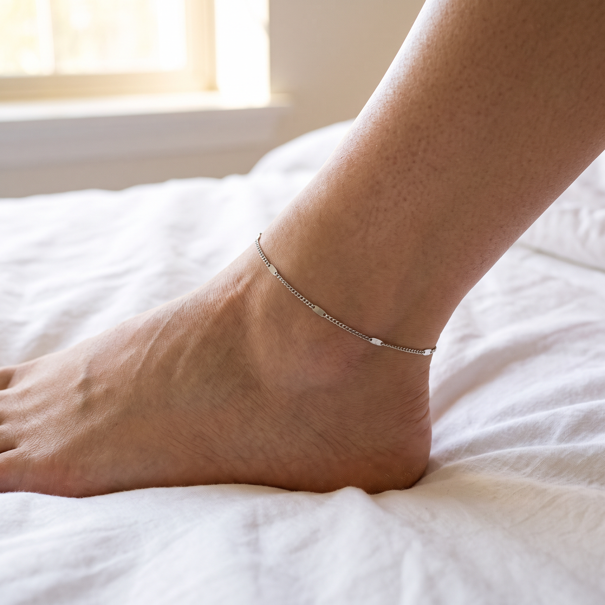 Elin silver chain anklet worn on white linen