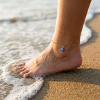Mati gold evil eye anklet worn on the beach at golden hour