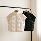 Nora puffer vests in white and black on a rail