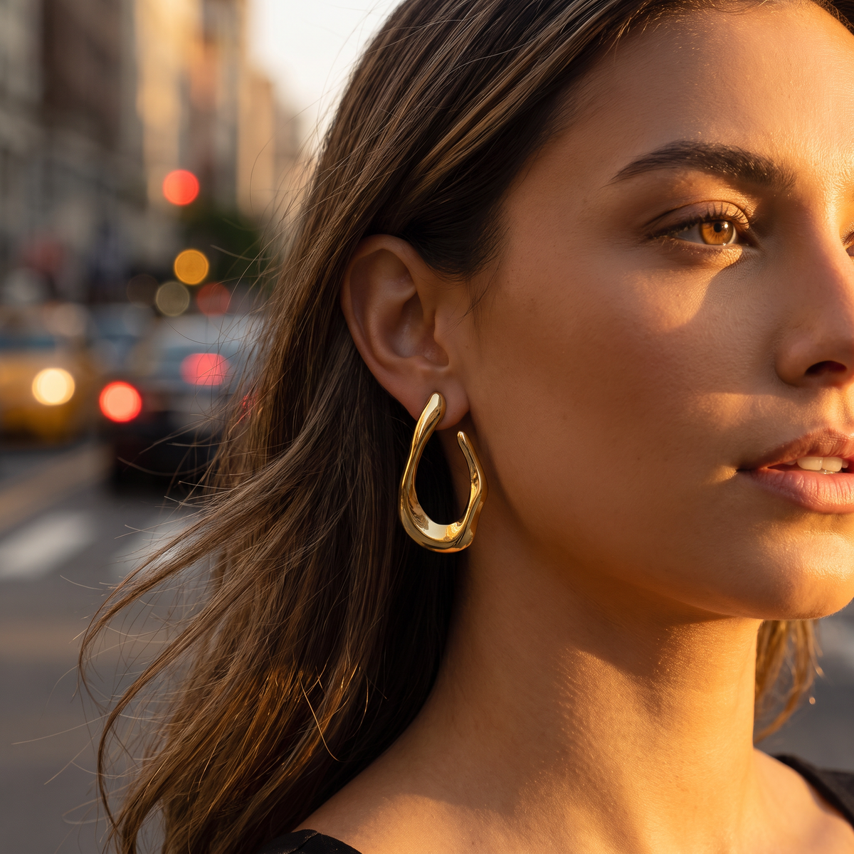 Amara sculpted gold hoop worn in golden hour light