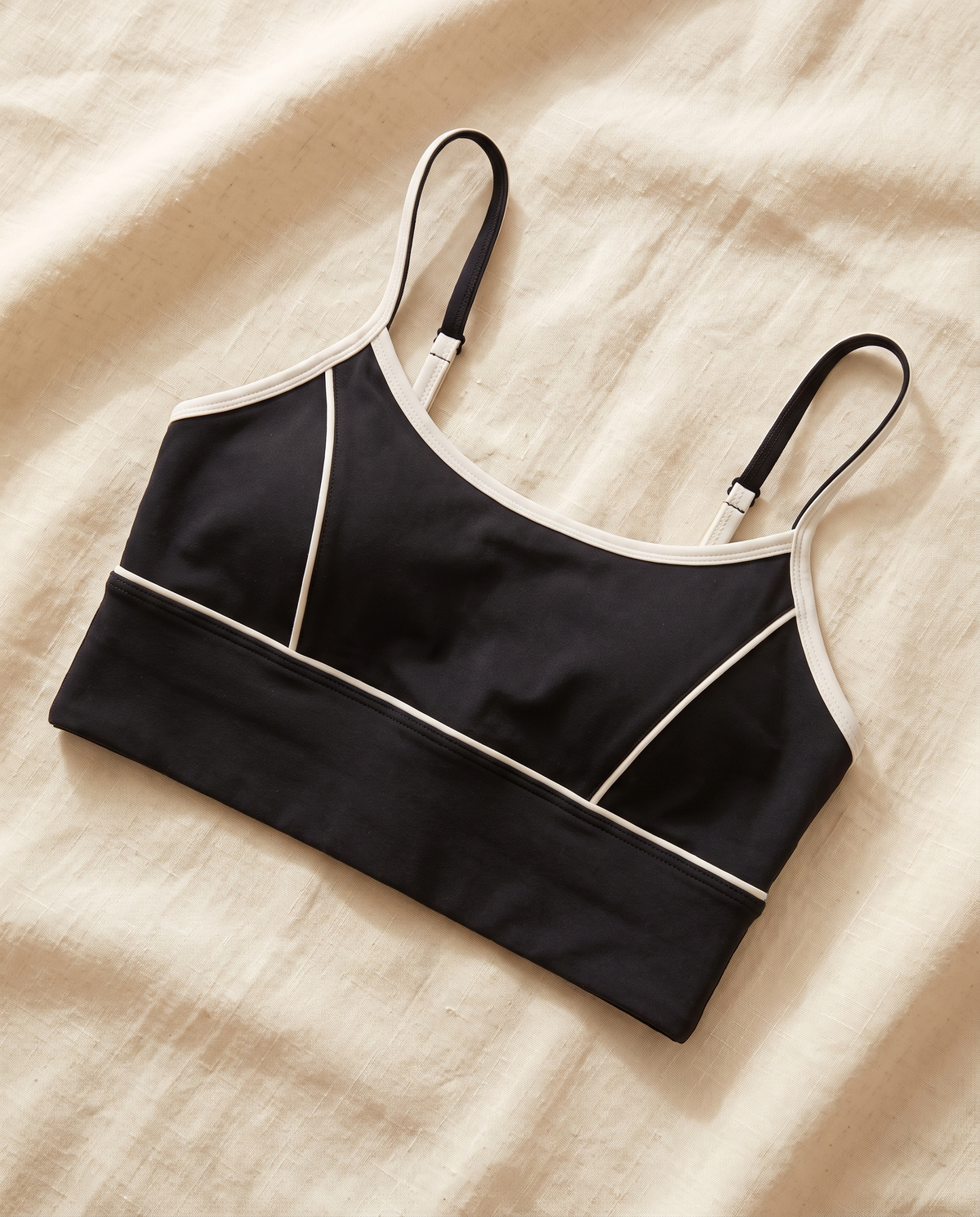 Mira sports bra laid flat on cream linen