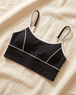 Mira sports bra laid flat on cream linen