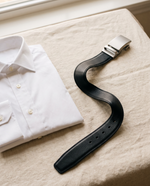 Halden belt laid beside a folded dress shirt