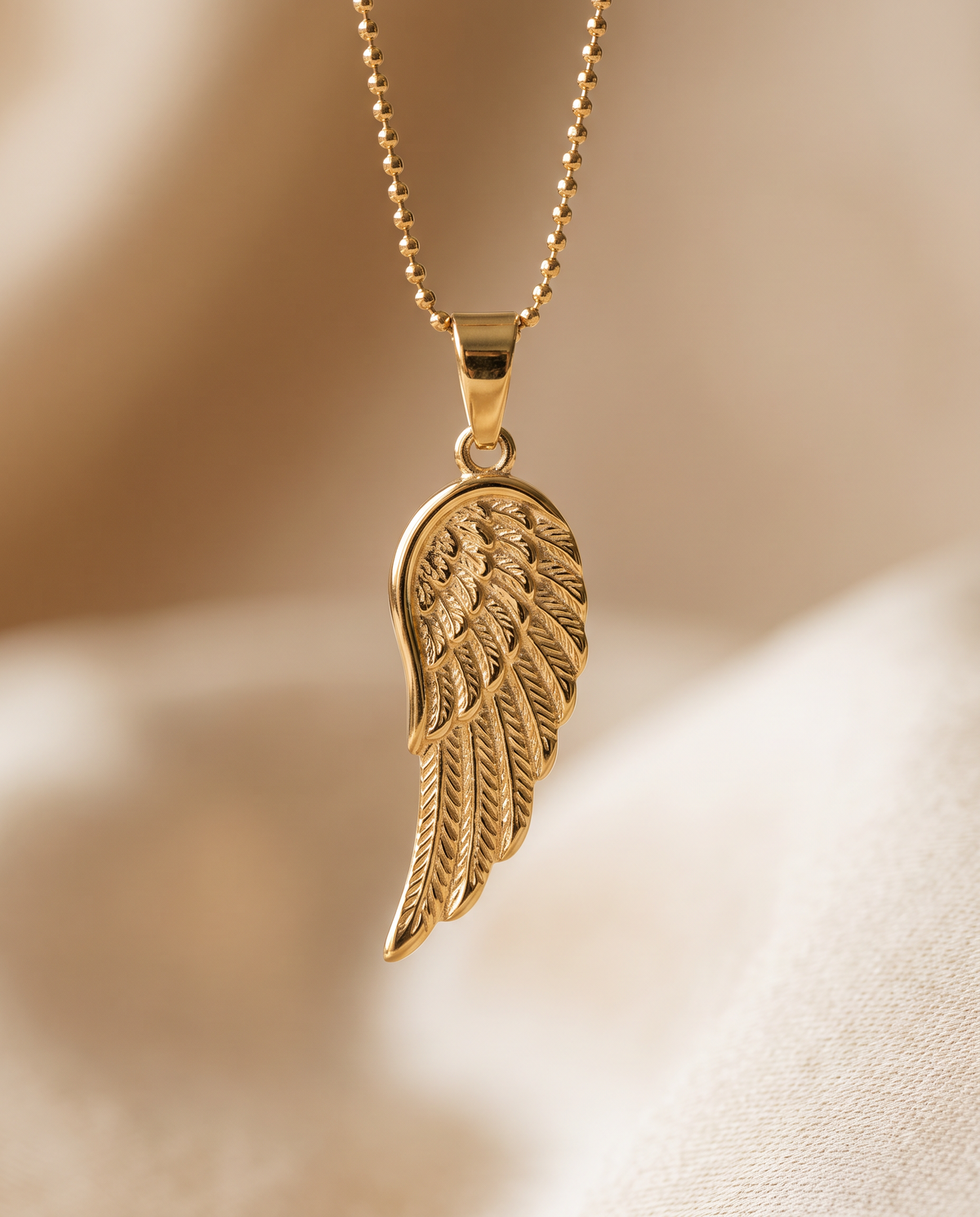 Close up of the engraved angel wing charm