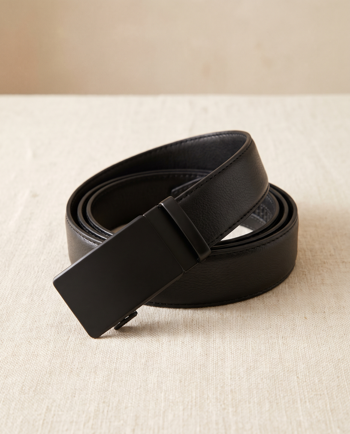 Rein ratchet belt coiled on cream linen