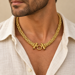 Gold Castor necklace worn over an open collar shirt