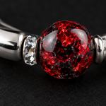 Close up of a red and black crackle bead and crystal spacer