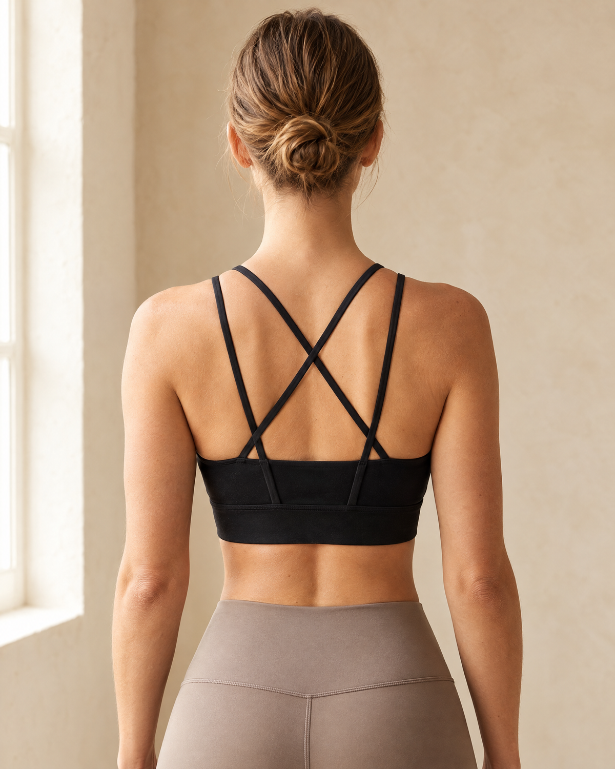 Orla Lattice Back Sports Bra in black, seen from behind showing the criss-cross straps